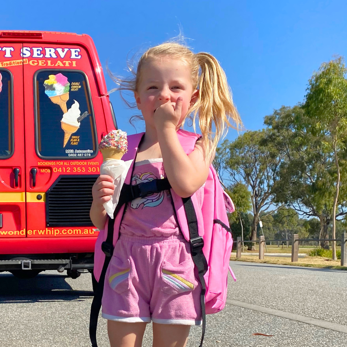 Girl wearing jude&moo Ice cream Truck Kids Backpack in front of ice cream truck.