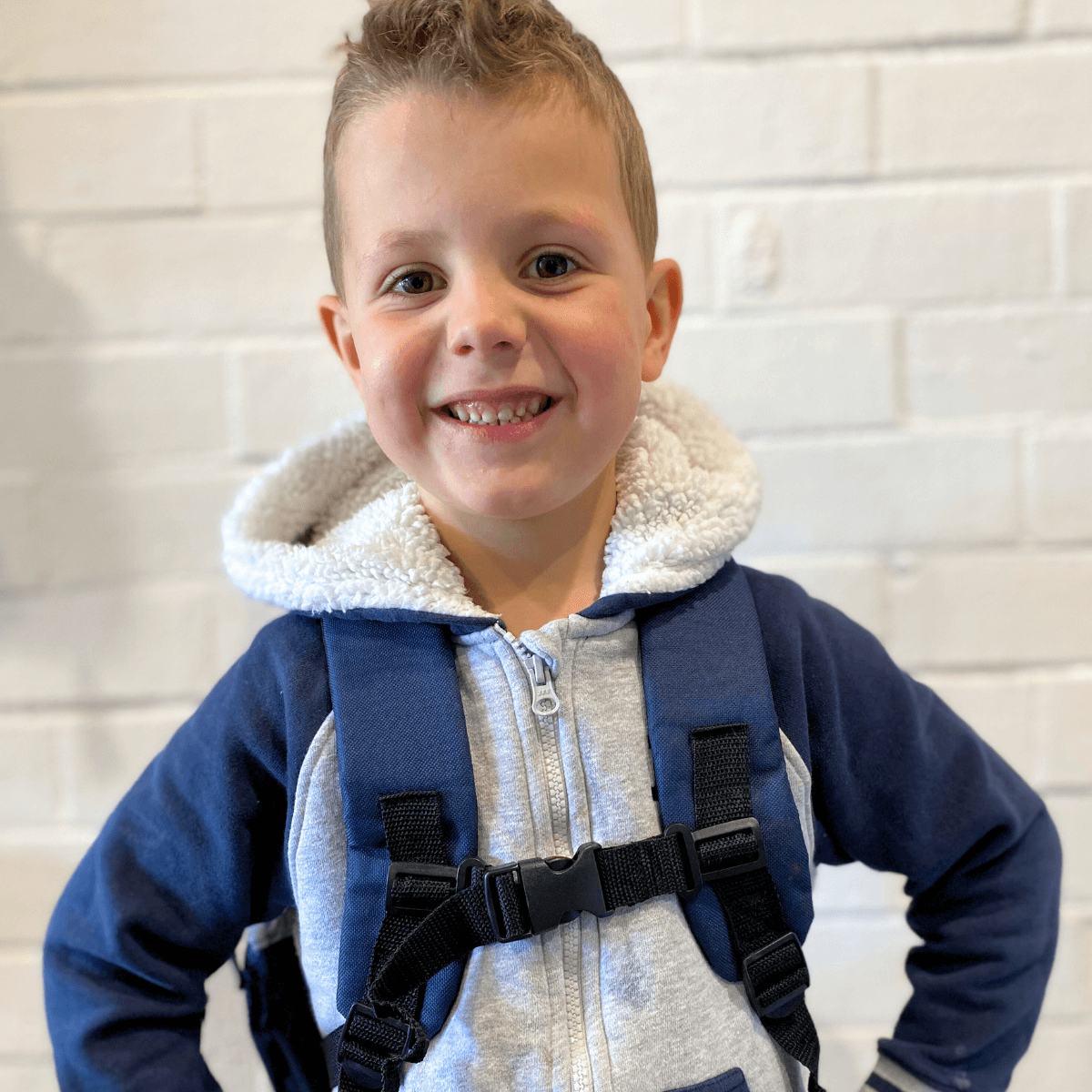 Boy wearing jude&moo kids police car backpack with chest strap