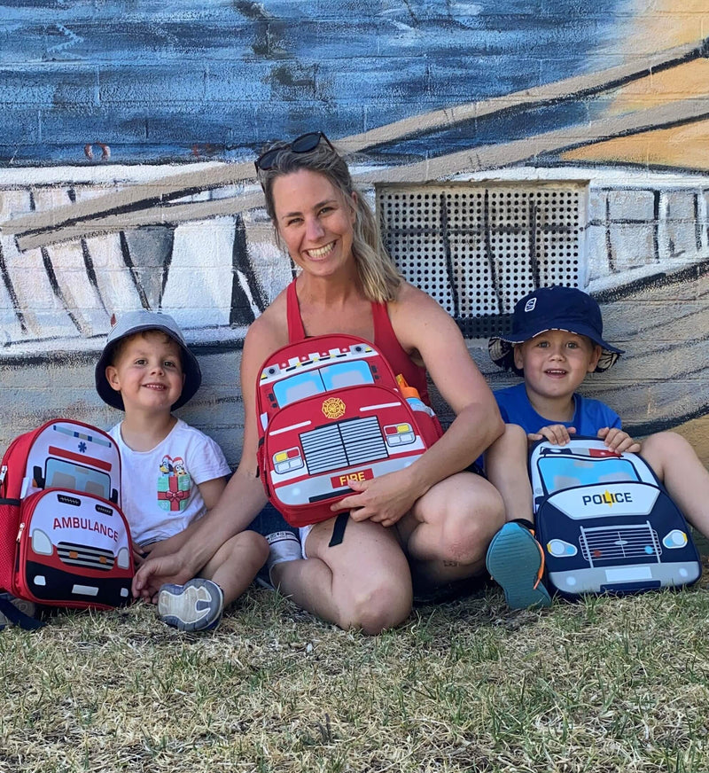 Kate Saunders founder of jude&moo car backpacks with her sons and the fire truck, police car and ambulance backpack.